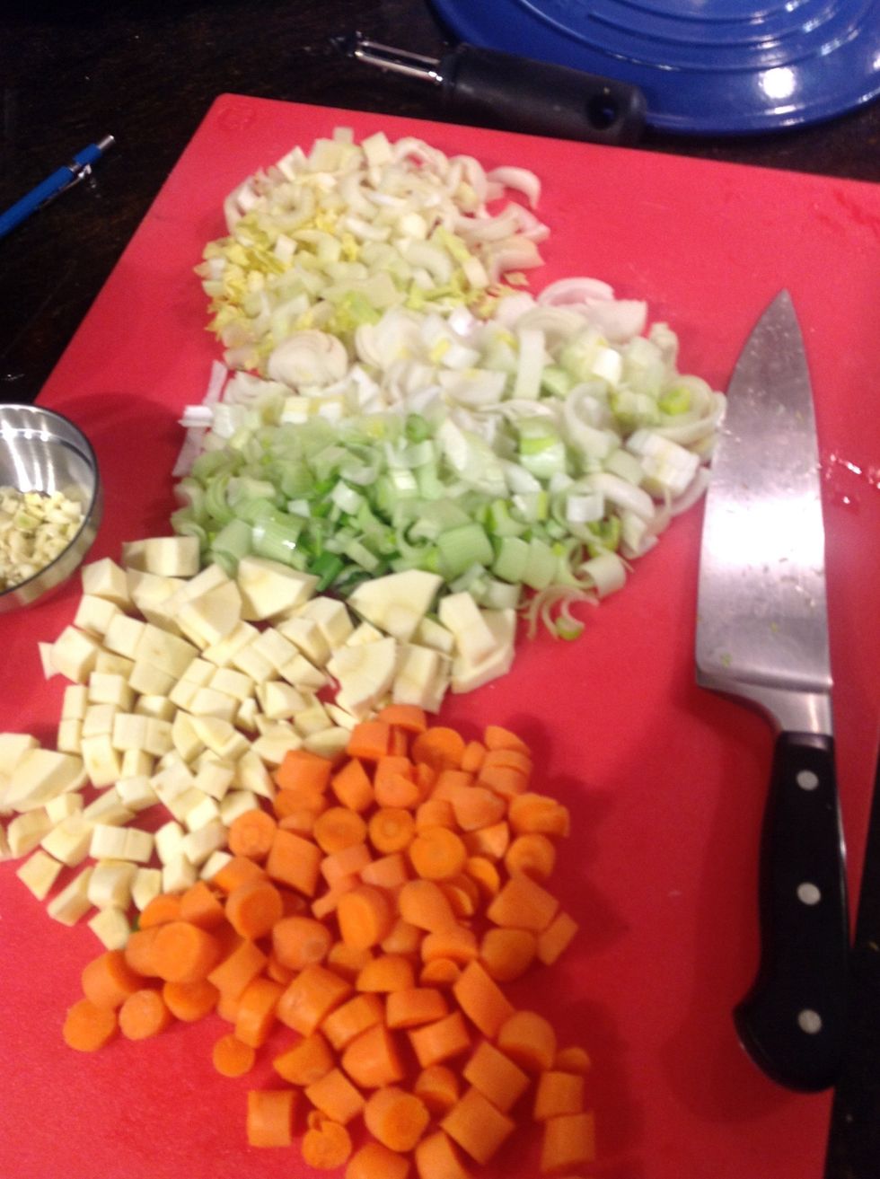 Coarsely chop celery heart, sweet onion bulbs, parsnip and portion of carrot (about 1 heaping cup) and saut\u00e9 in pot with lamb fond at medium heat.