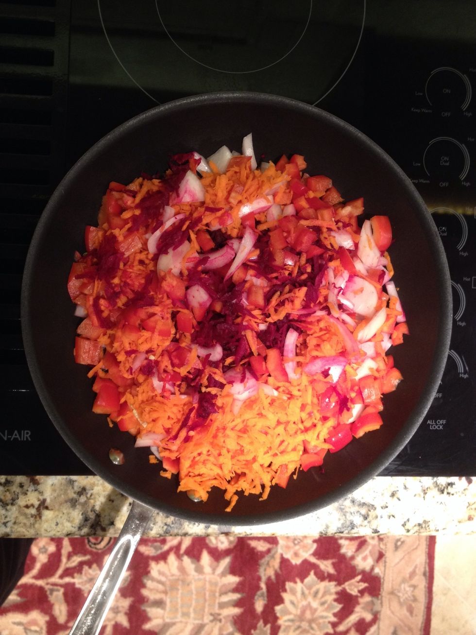 Coarsely shred beet(s) and carrot(s). Finely chop onion(s) and pepper. Mix them together with olive oil and tomato paste in a large skillet and cook over mid heat, stirring frequently.