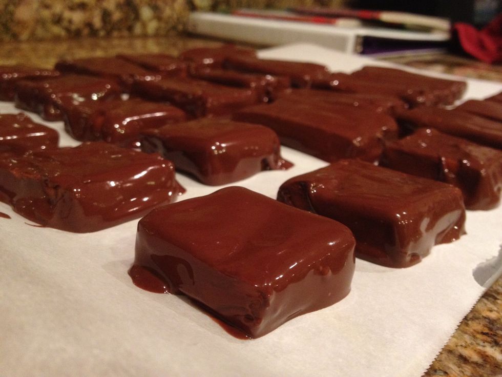 Coat the copycat Butterfingers and place them on a parchment lined tray. Put that in the fridge to set up. To save time, you could simply spread chocolate on the uncut block and let it set.