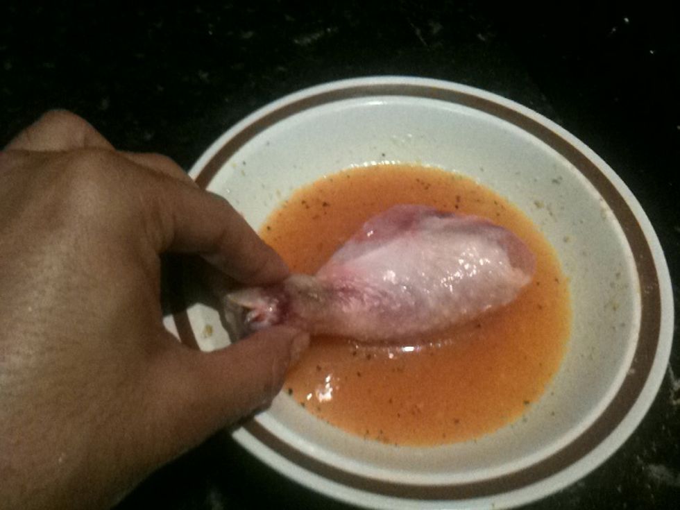 Coat the drumstick with egg by dipping it in the bowl.
