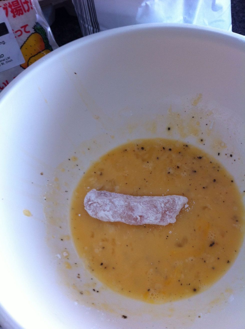 Coat the flour-covered fish in the beaten egg mixture; this mixture contains salt and pepper and a splash of mirin (optional)
