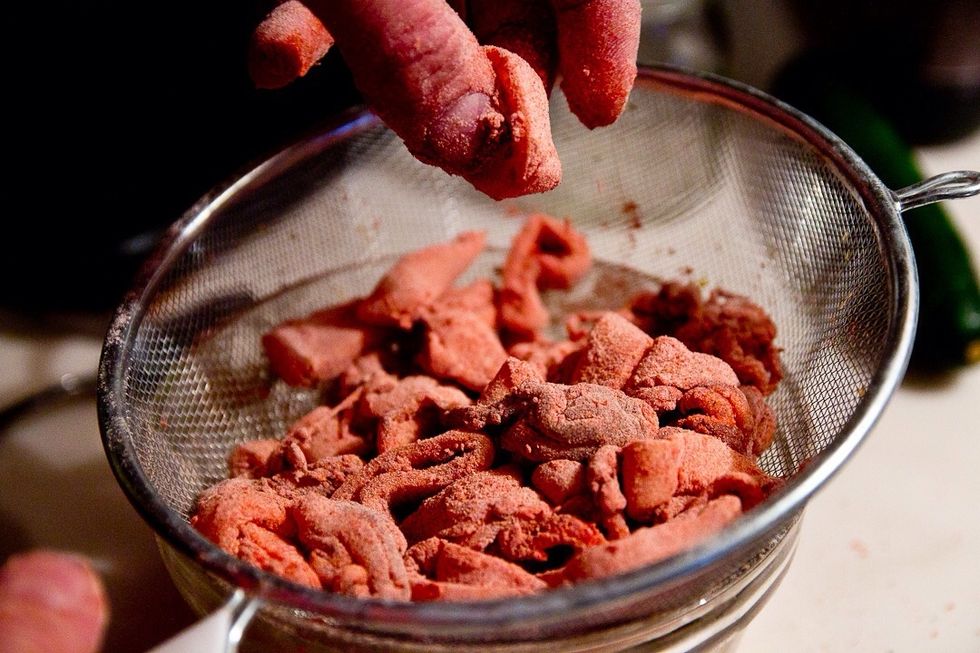 Coat with the seasoned flour mixture. Make sure to evenly coat all of the pieces. I use a mesh strainer over a bowl and flick the pieces around. Then take the seasoning from the bowl and redo