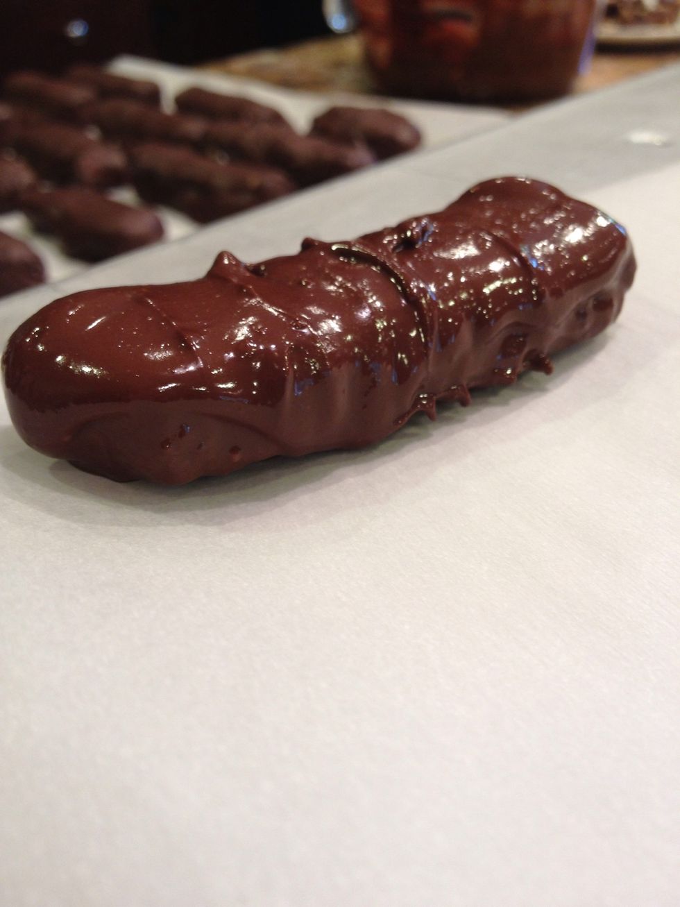 Coat your Twix-to-be bars in the chocolate.\ud83c\udf6b Place them on a parchment-lined tray and put that in the fridge to harden up.