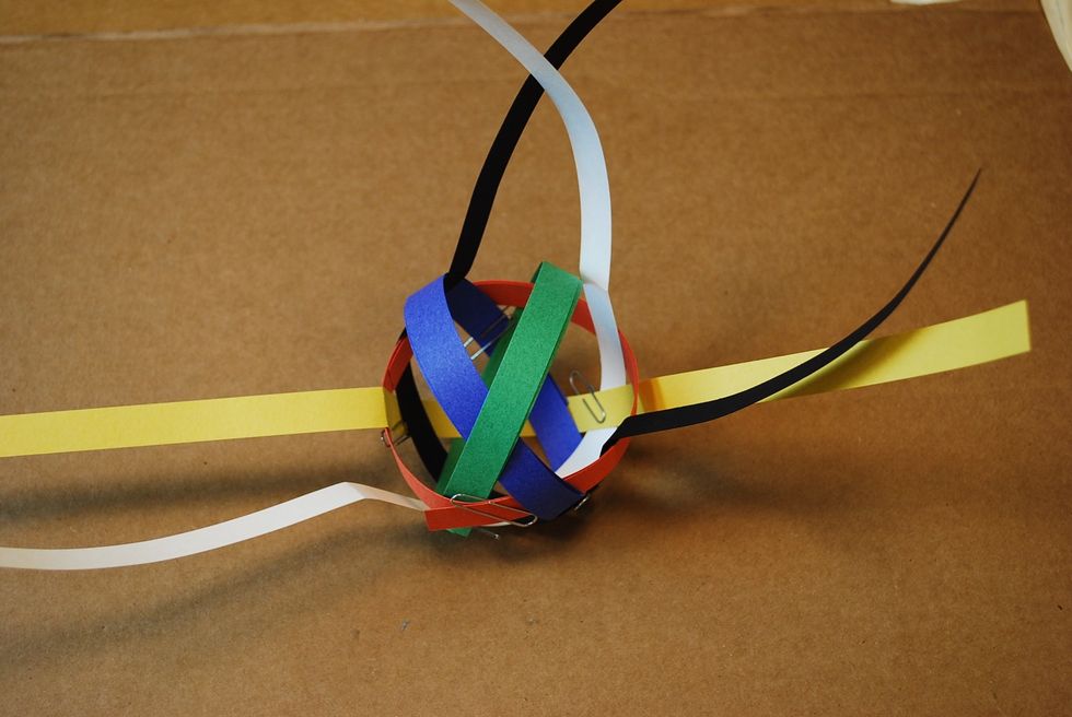 Coil the green strip to the size of the orange loop. Make sure the green loop is going over the blue loop as shown above.