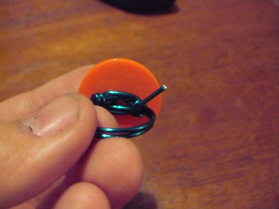 Coil the loose ends around the band of the Ring on each side. Then nip off the ends. Make sure to pinch the coils with the chain nosed pliers, or you could scratch yourself!