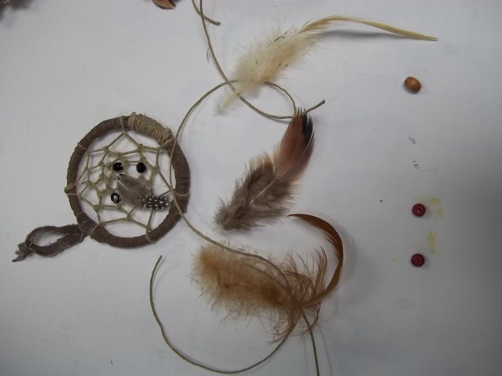 Collect 4 feathers, 3 beads, and 3 peices of hemp. and some glue. These numbers are not definite, you can make your dream catcher however you want.