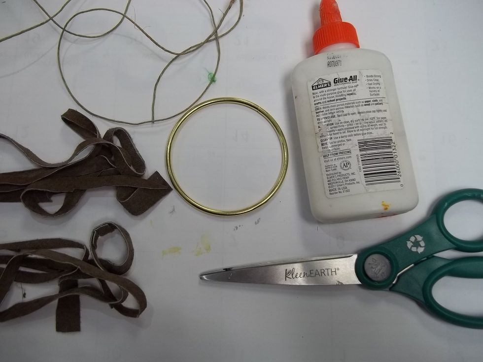 Collect strips of suede to wrap around the hoop. I found a peice of suede at a thrift store and cut it into strips. I will be using glue sparingly to help secure knots as I go.