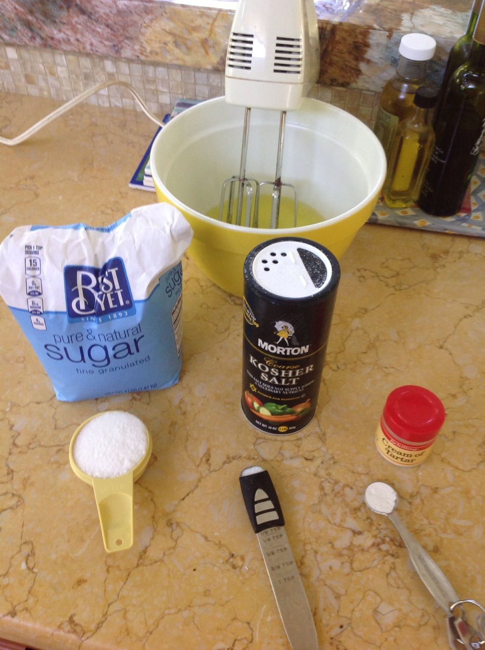 Collect sugar, cream of tartar, and salt. Add salt and cream of tartar to the egg whites and beat at medium-high speed until soft-peaked. It's at soft peak when it can almost be formed into a peak.