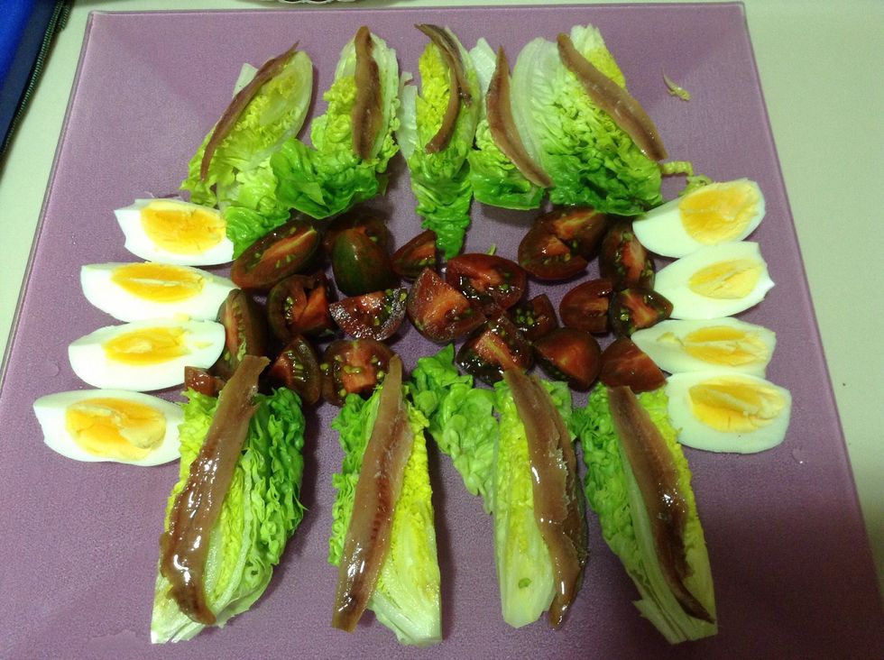 Colocar los ingredientes, con las anchoas encima de la lechuga