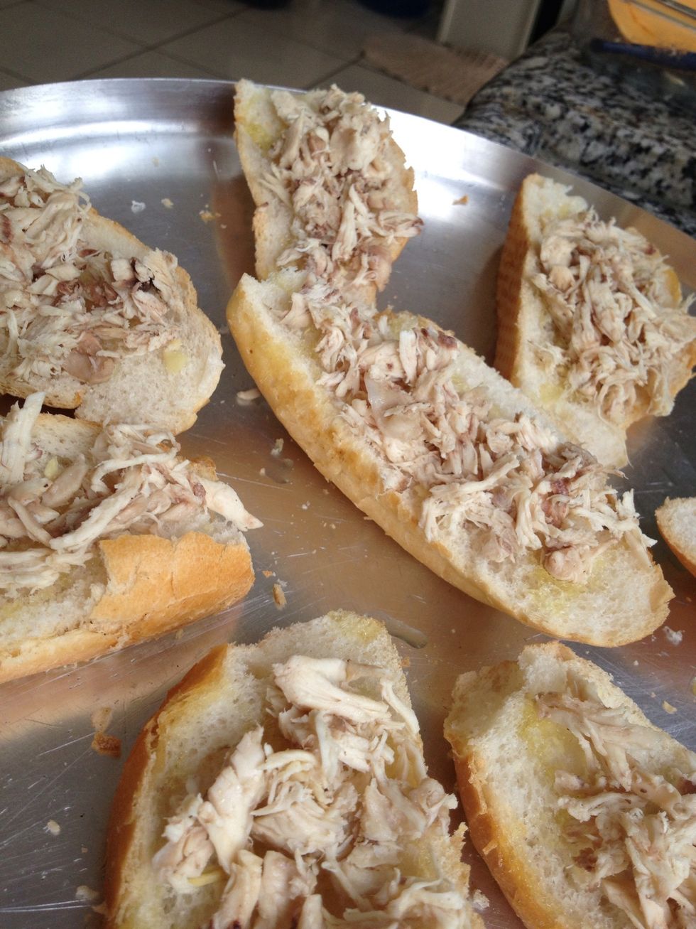 Coloque sobre os p\u00e3es com alho, o frango desfiado.