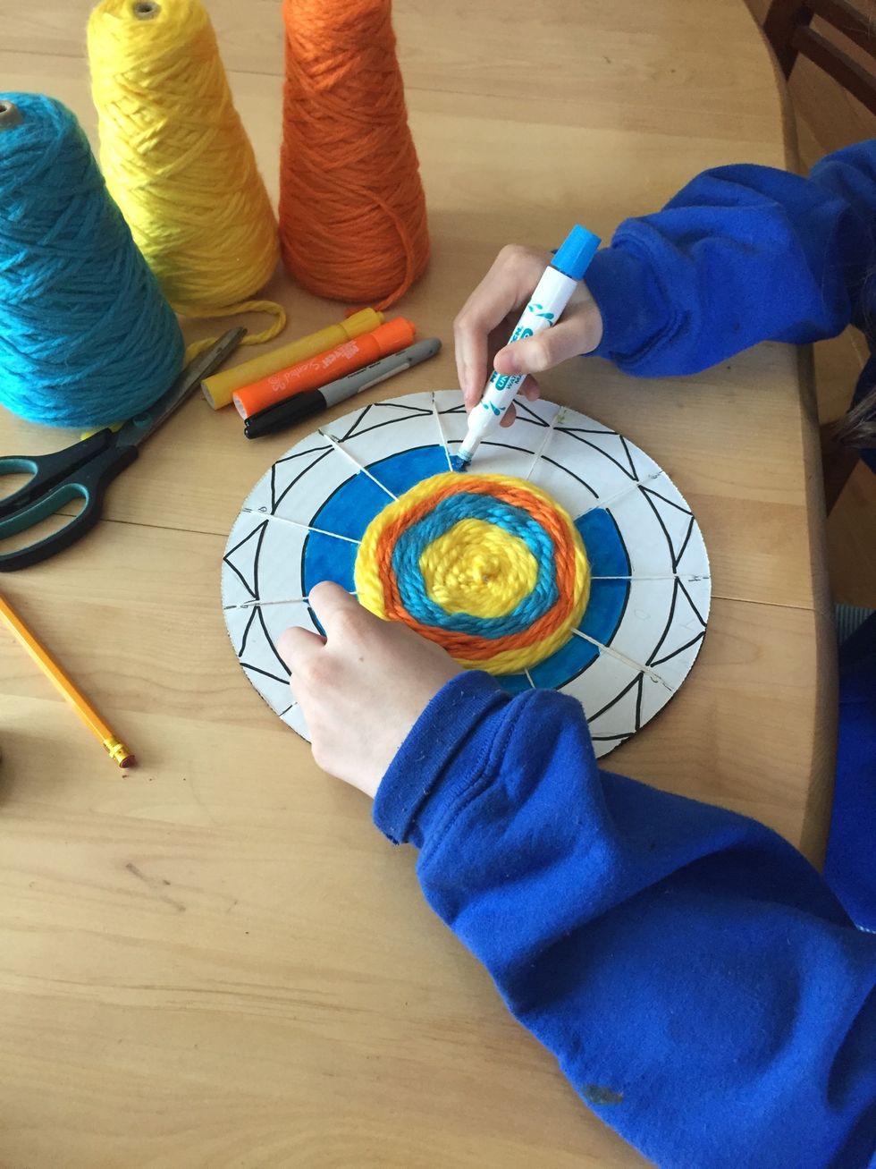 Color the radial design using the same yarn colors that you used. If you would like to, you can outline your radial design in black Sharpie marker.
