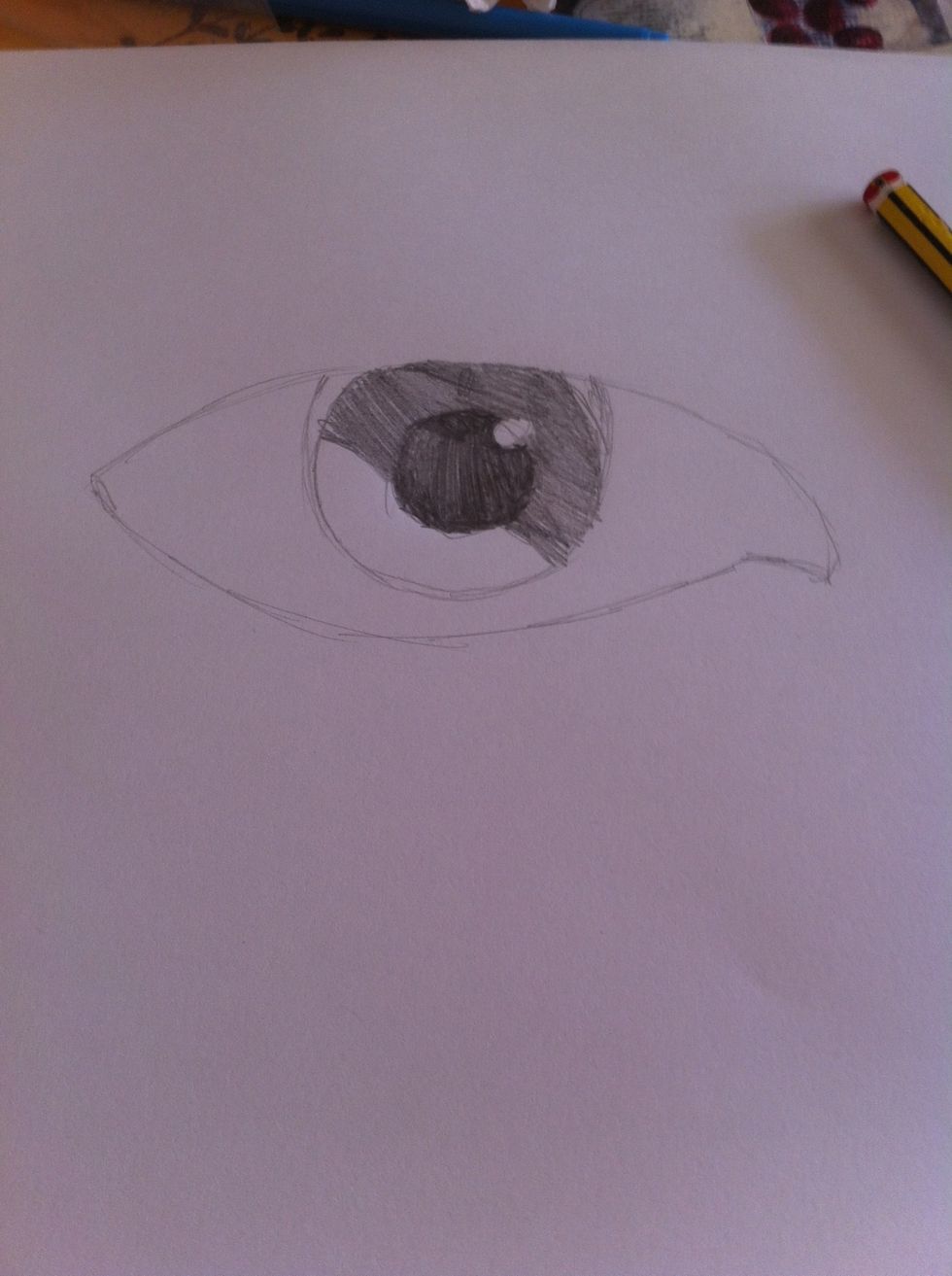 Colour half of it in with a dark shadow about 1 shade lighter than the pupil