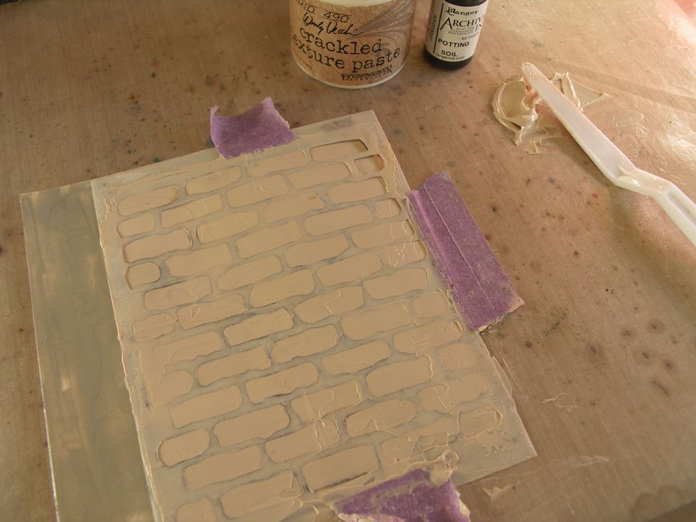 Colour some crackled embossing paste with Potting Soil Archival Reinker and apply it over the silver base through a brick stencil. Once again, allow to dry and crack.