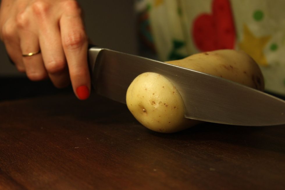 Com uma faca ben afiada, fa\u00e7a fatias bem finas na batata at\u00e9 um pouco mas da metade, mas sem cort\u00e1-la at\u00e9 o final.