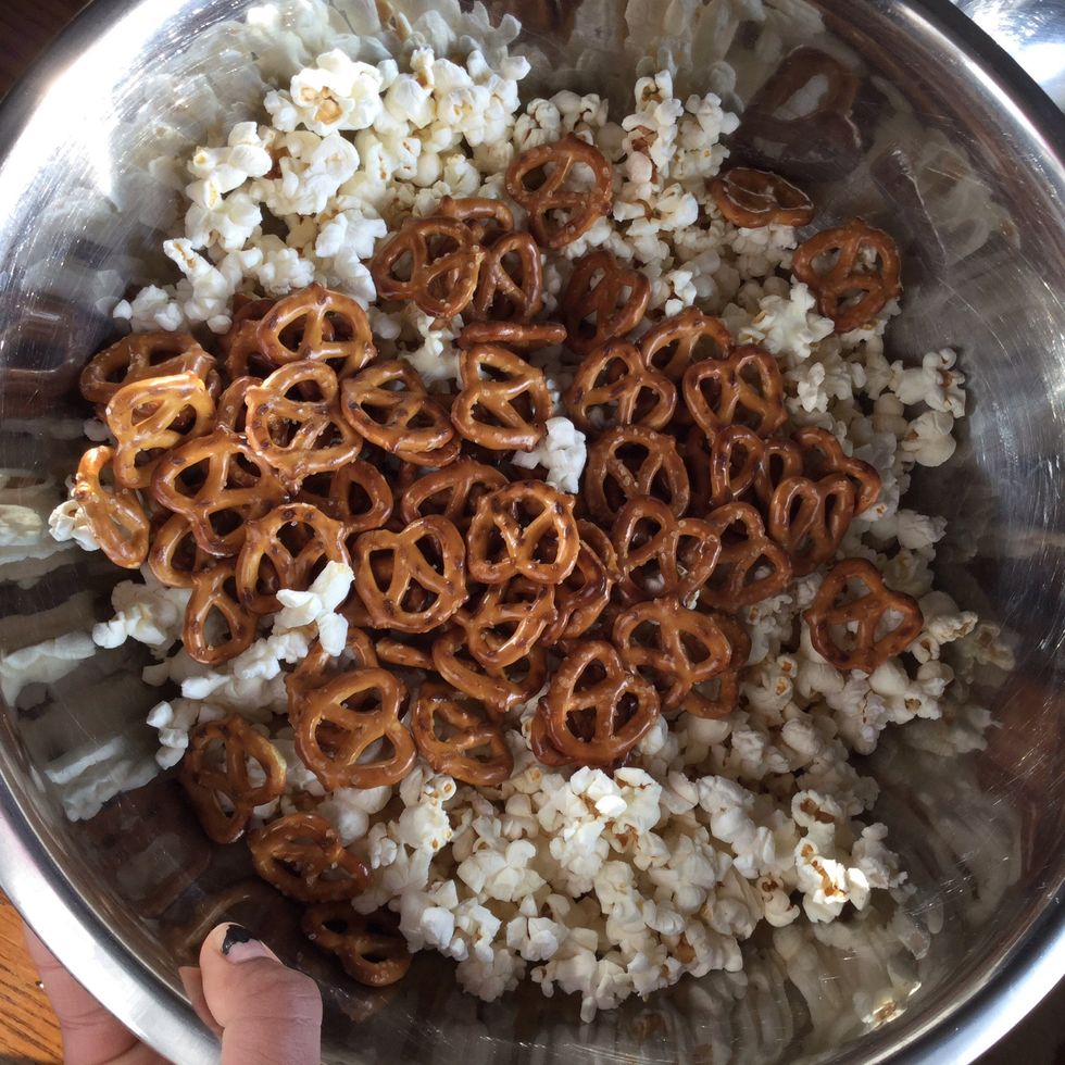 Combine half a bag of pretzels into the bowl.