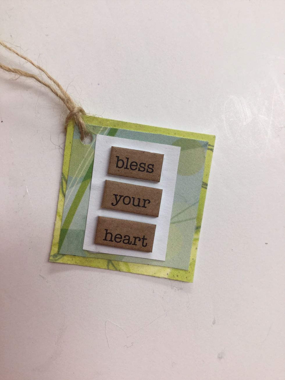 Combine papers and stickers to create a tag with a "sweet sentiment." Punch a hole in the corner and loop the twine through the hole.