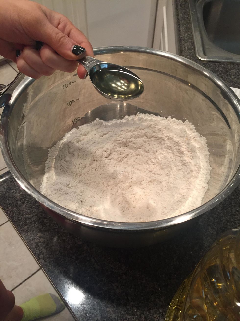 combine the canola oil with the other ingredients and mix it together with your hands until it resembles cornmeal