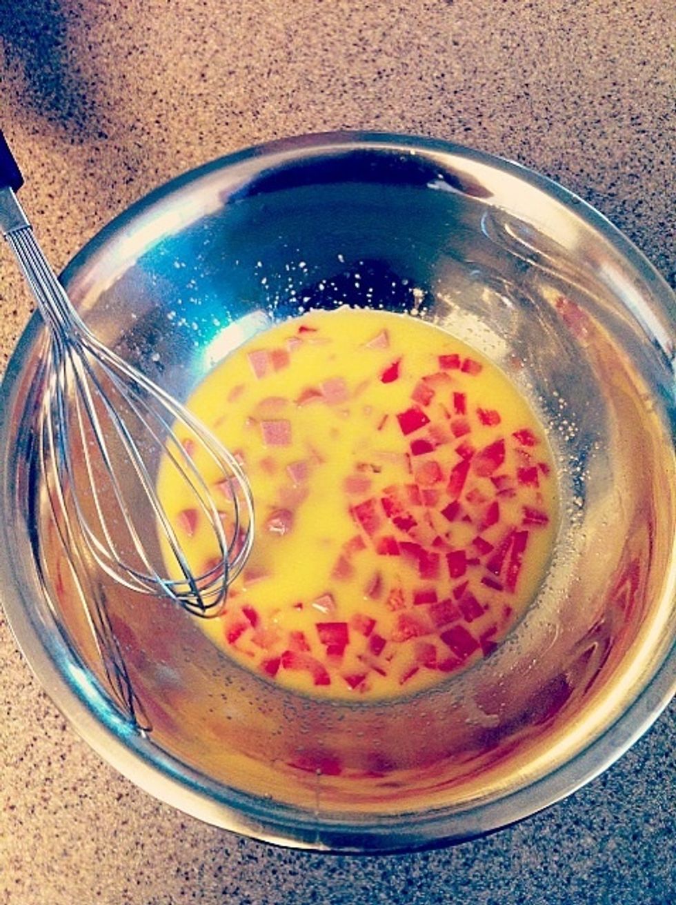 Combine the eggs, garlic powder, hot sauce, onion powder, salt and pepper and milk. Whisk together until the egg are light & frothy. Then, add the bell pepper & sausage cubes to the egg mixture.