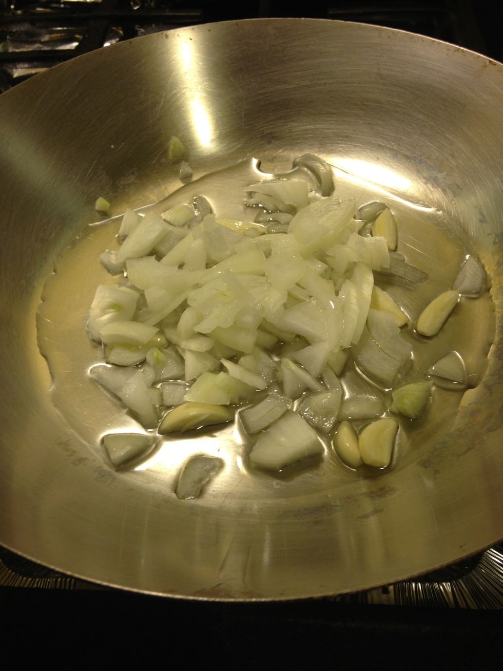 Combine the onions, garlic and oil into a pan and cook over a medium heat.