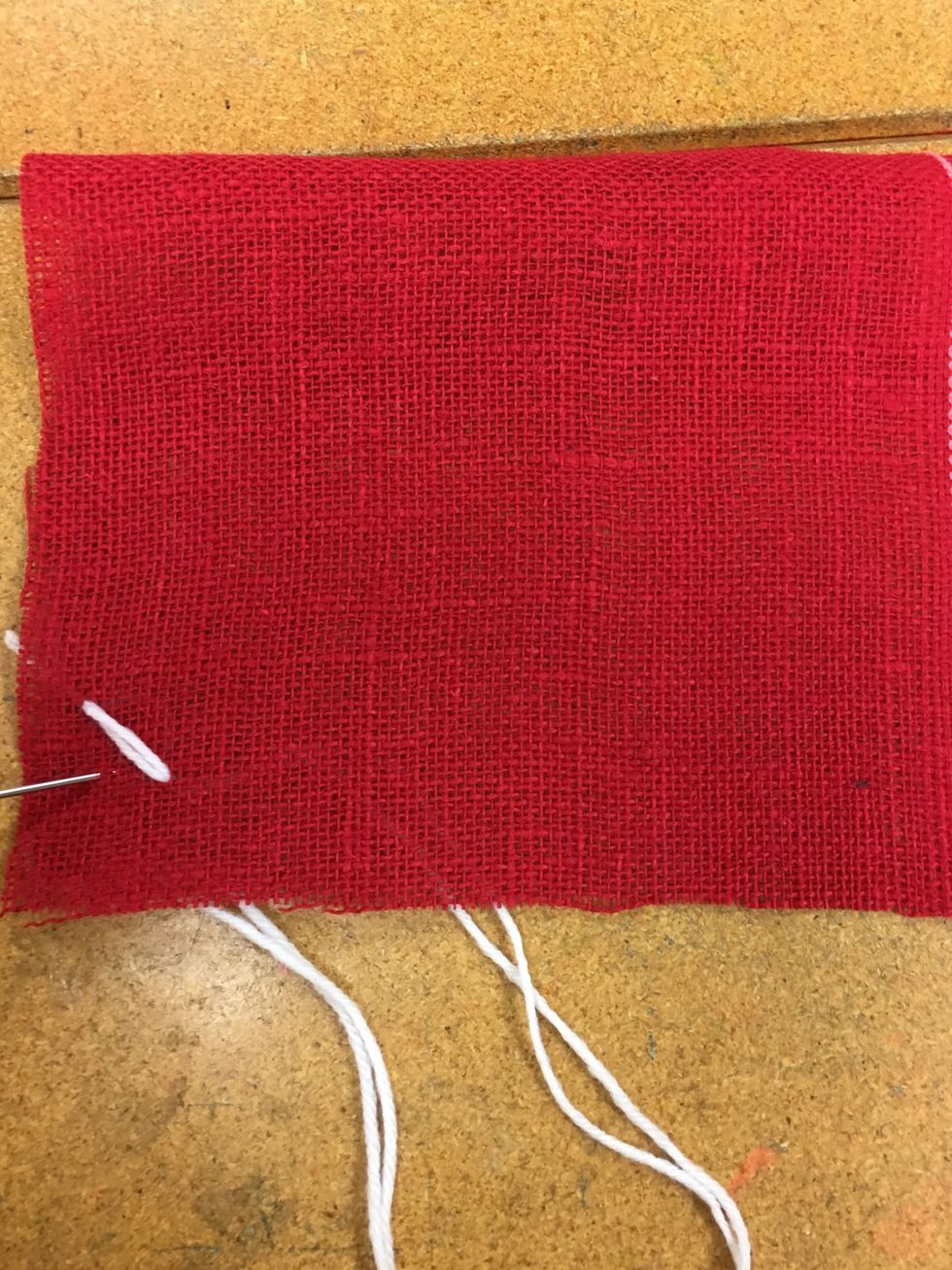 Come up through the fabric in the left corner.