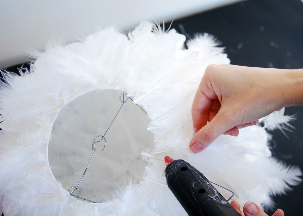 Complete to glue the top of the lantern with fluffy small feather and sprinkle them well over the entire lampshade to create volume.