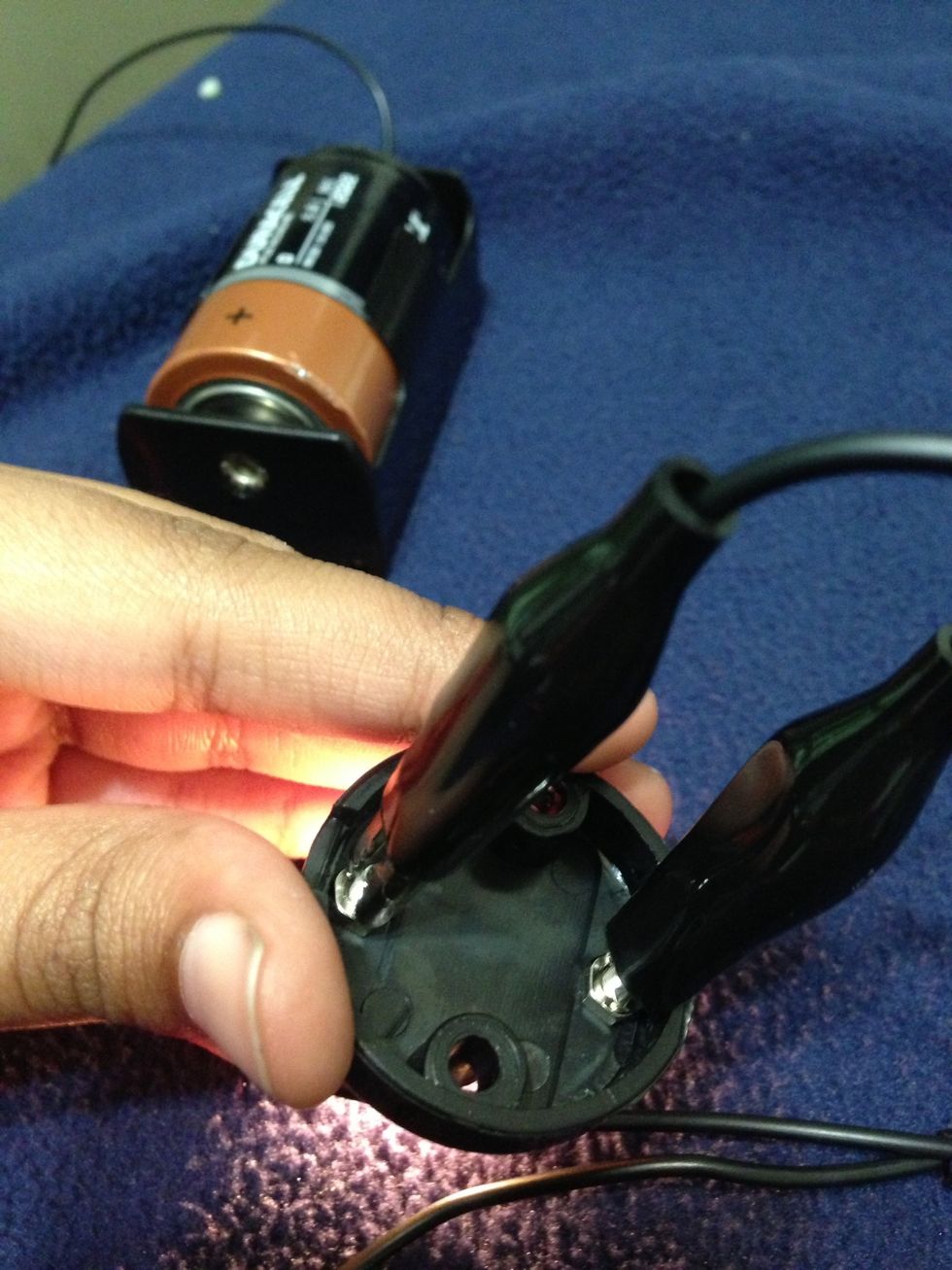 Connect the two alligator clips to the lightbulb.