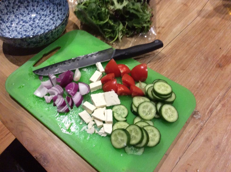 Continuation of step 2: Cut the rest of the ingredients and then put some olives into a small bowl. Also, remember to open the bag of multiple lettuces.