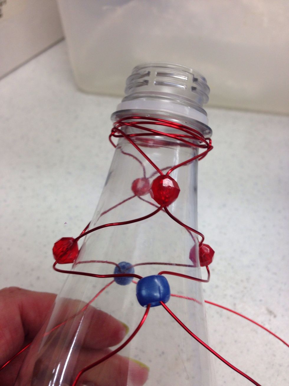 Continue adding beads in this manner until you have covered the bottle with beads and wire.