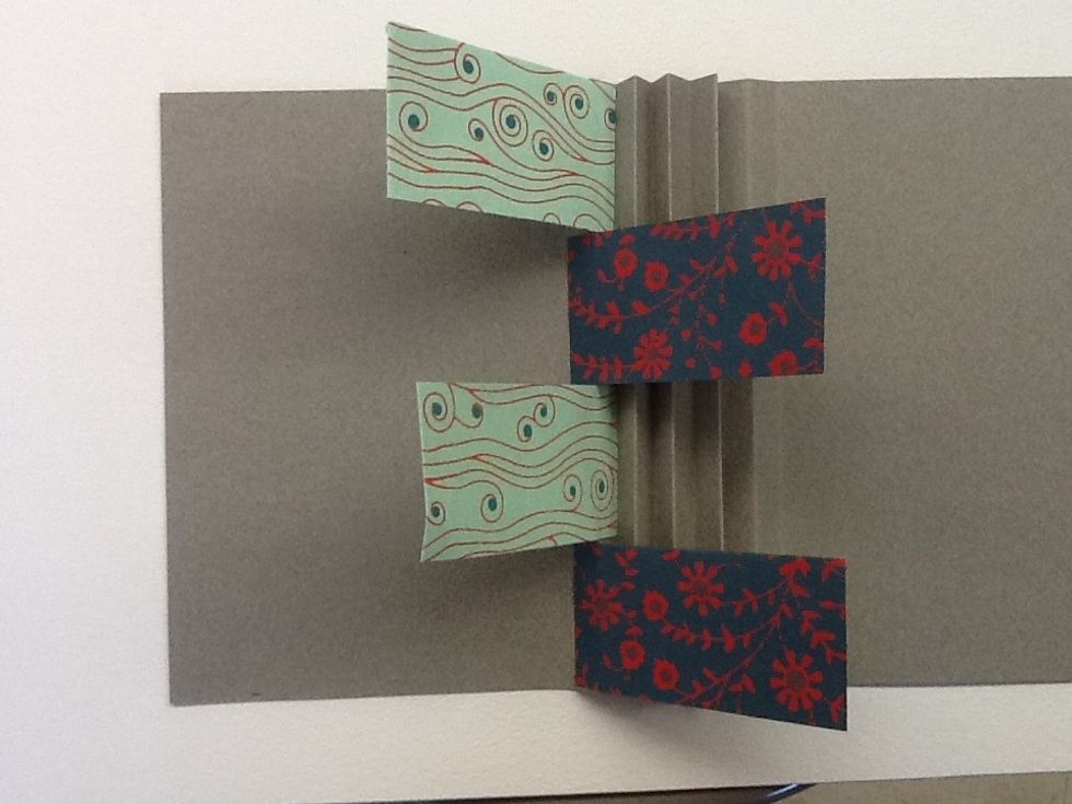 Continue adding flags in the first row, alternating their position inside and outside along the fold.