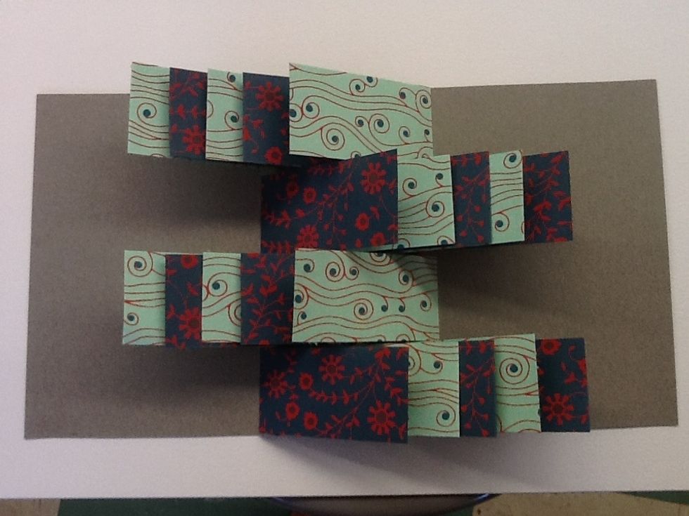 Continue adding flags working one row at a time, remembering to alternate inside and outside the fold when you glue.