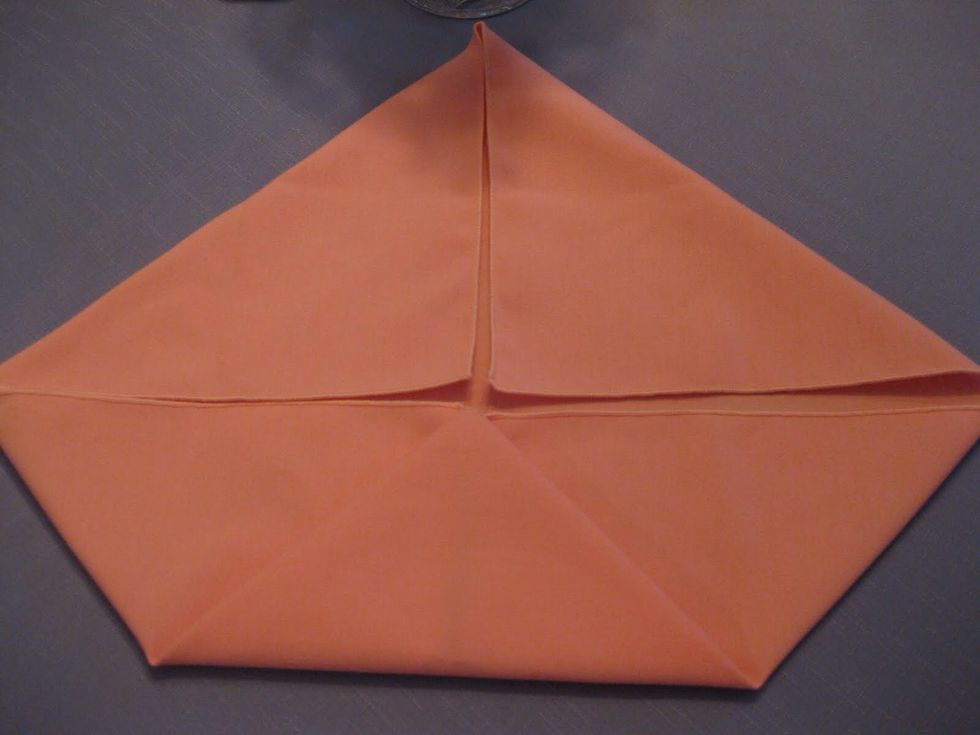 Continue again to fold the corners to the middle of the napkin.