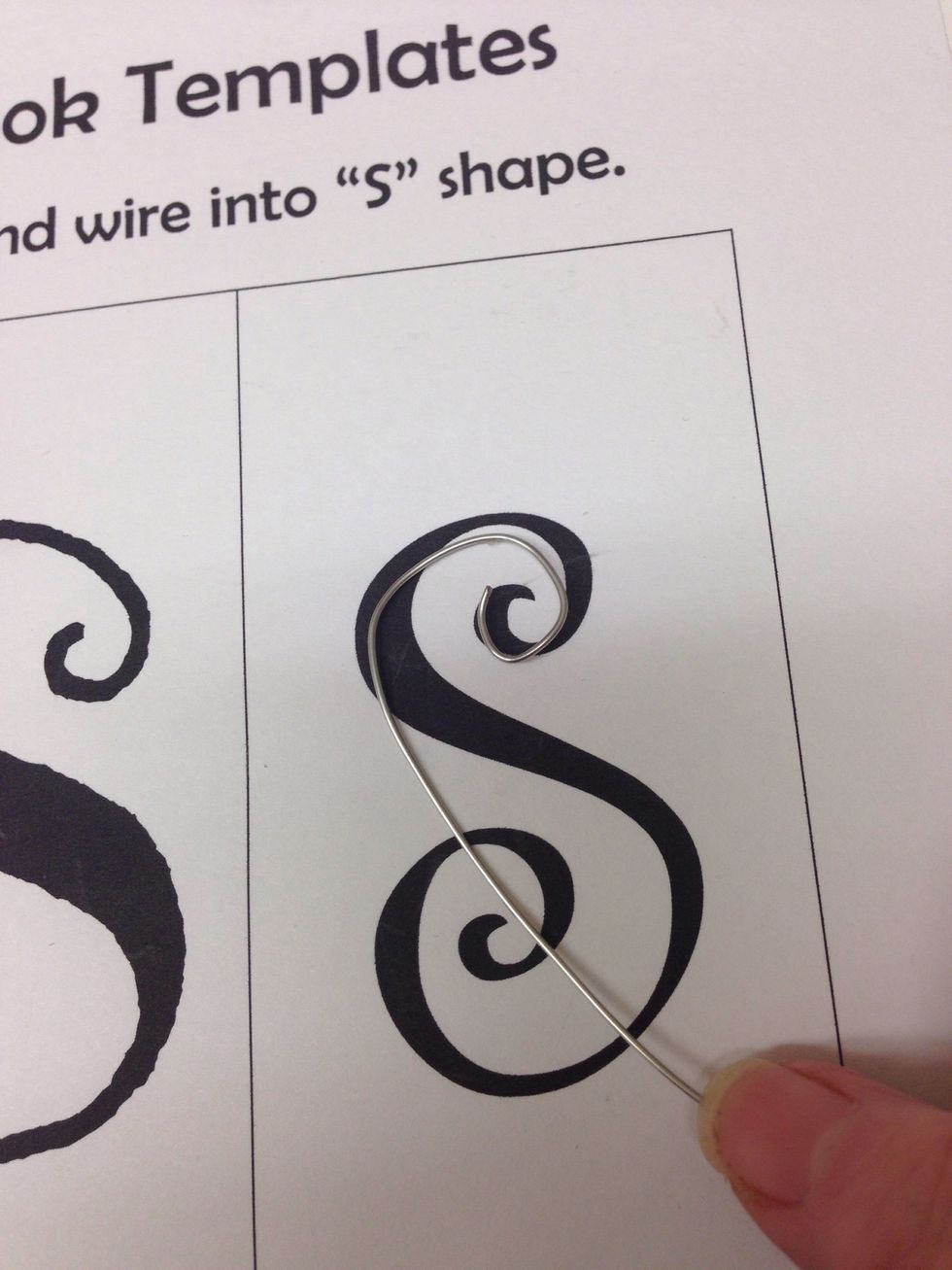 Continue coaxing the wire into the S shape using the template as a guide.