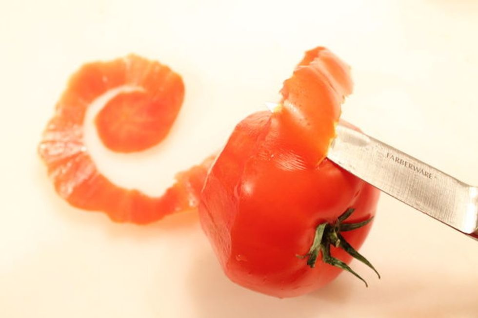 Continue cutting around the tomato, keeping the skin all in one piece. Gradually make the strip of tomato skin slightly narrower as you get closer to the core.