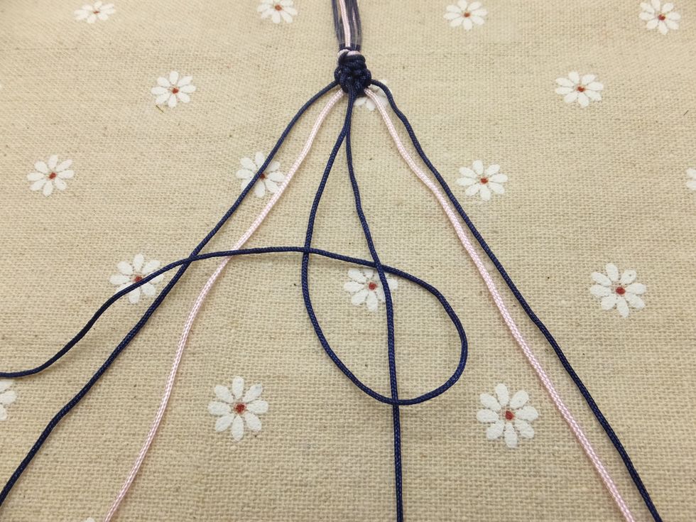 Continue knotting towards the right until the outermost cord reaches the middle. Tie a forward knot with the two middle strands to connect the two halves. The first chevron row is complete!