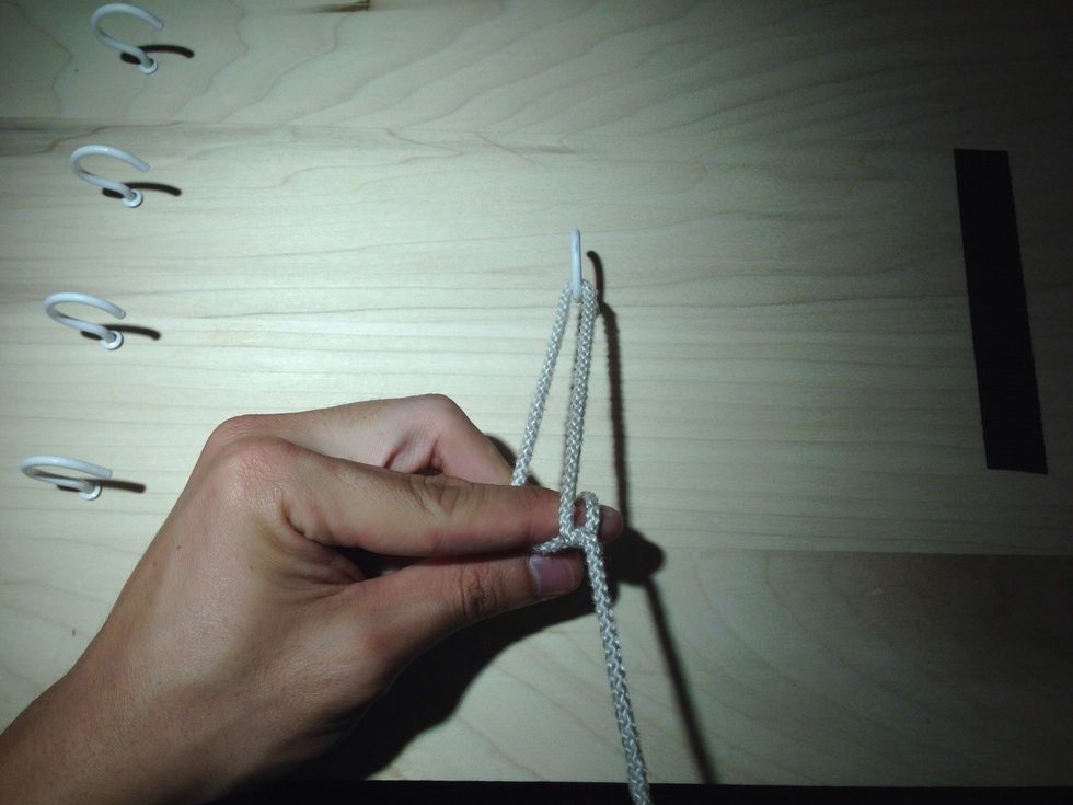 Continue pushing with the index finger as you "throw" (guide) it through the loop. Get ready to extend the middle finger of your throwing hand to catch the free end of the suture.