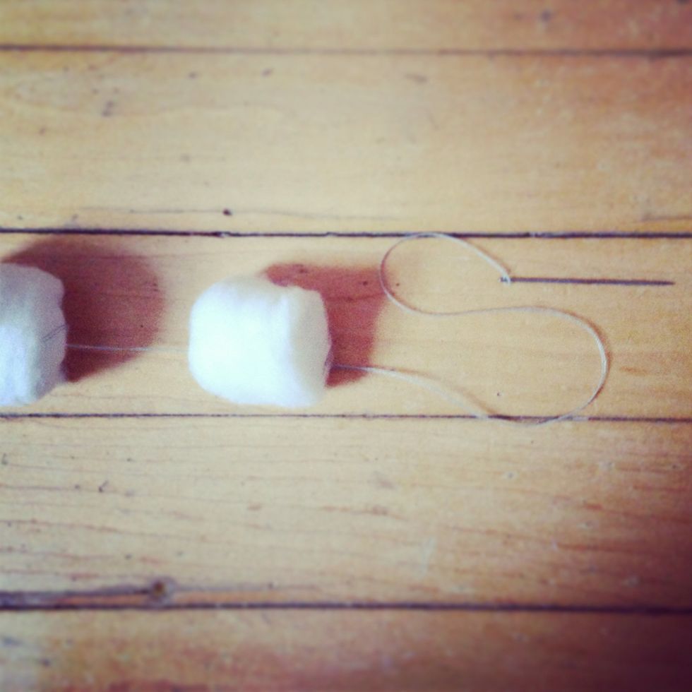 Continue threading cotton balls and creating knots until you reach the desired length of strand.