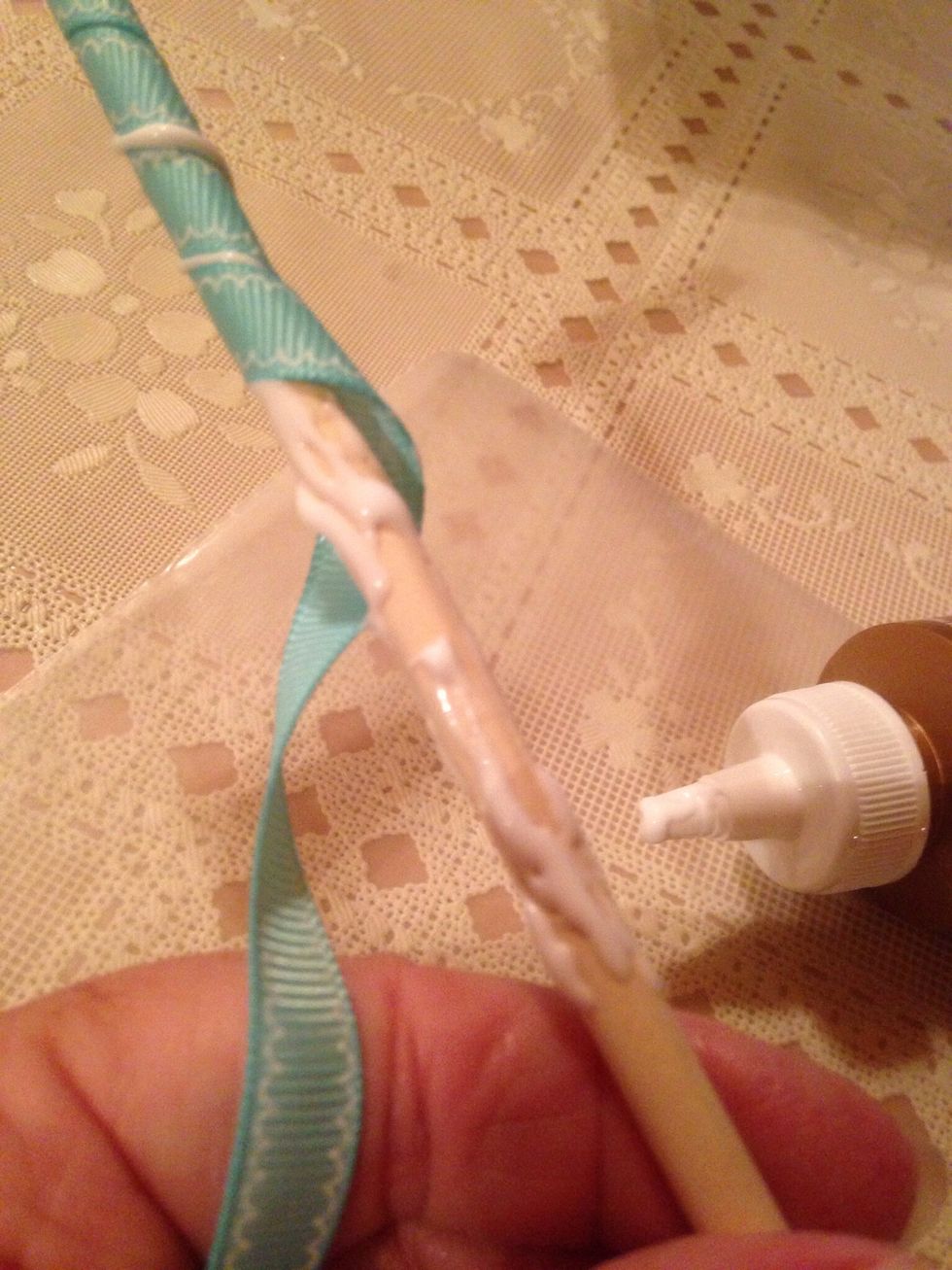 Continue to add glue and wrap ribbon until the dowel is covered.