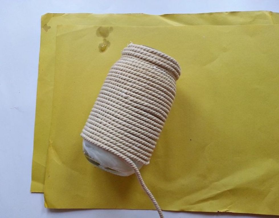 Continue to apply glue to the jar in sections and wrap the twine around the jar until you reach the bottom.
