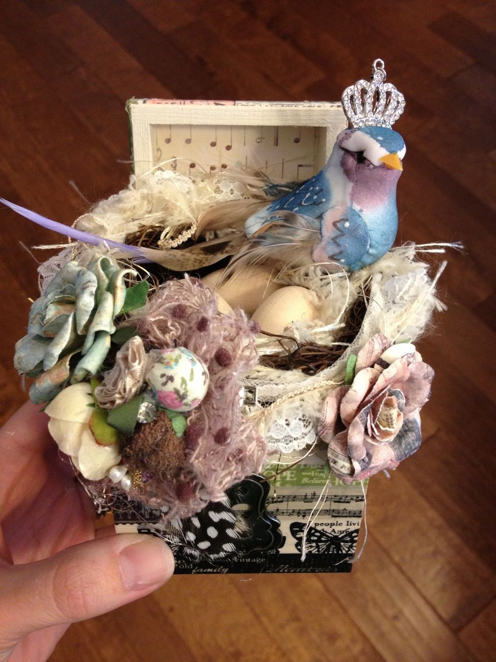 Continue to embellish the box using the paper flowers and adding the keyhole at the bottom.