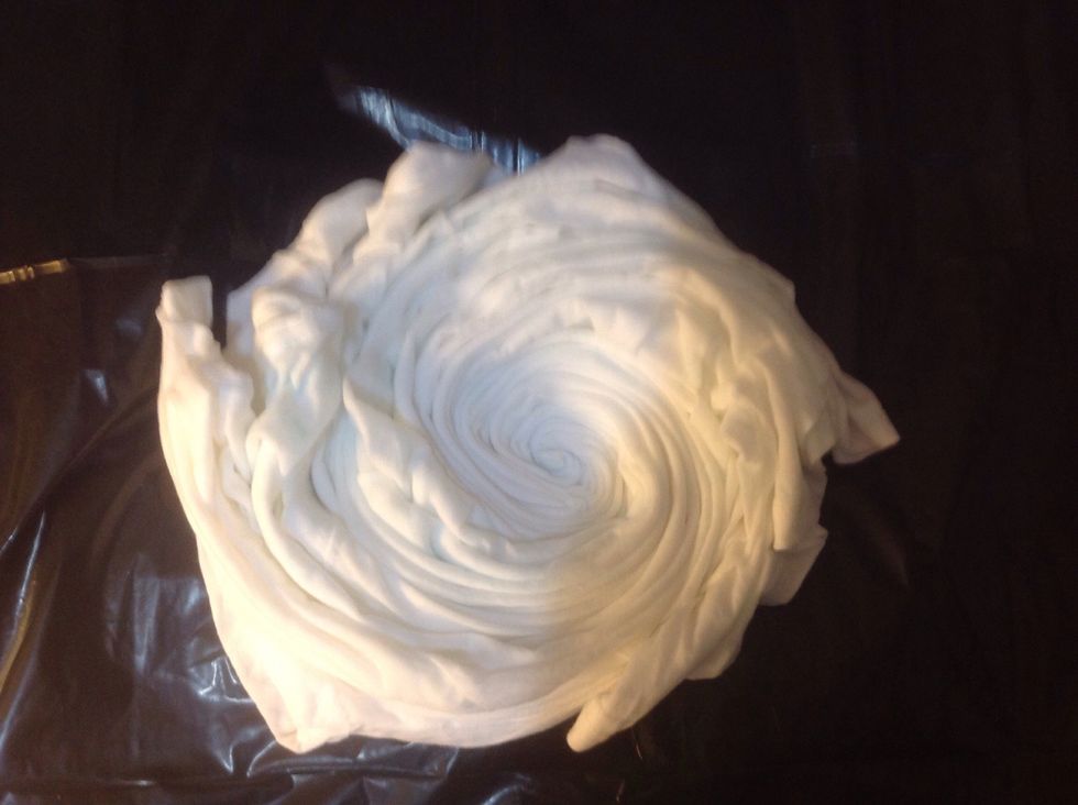 Continue to twist in a counterclockwise motion, keeping the t-shirt flat on the tarp.