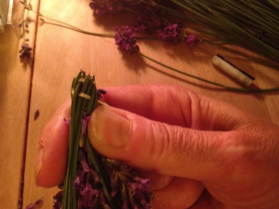 Continue to weave the string round the flower heads. Remove the small flowers that sticks out.