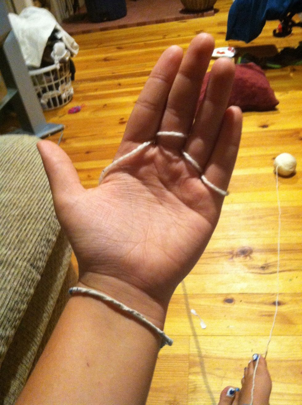 Continue to weave the yarn through your fingers again, then again, until each finger has two loops.