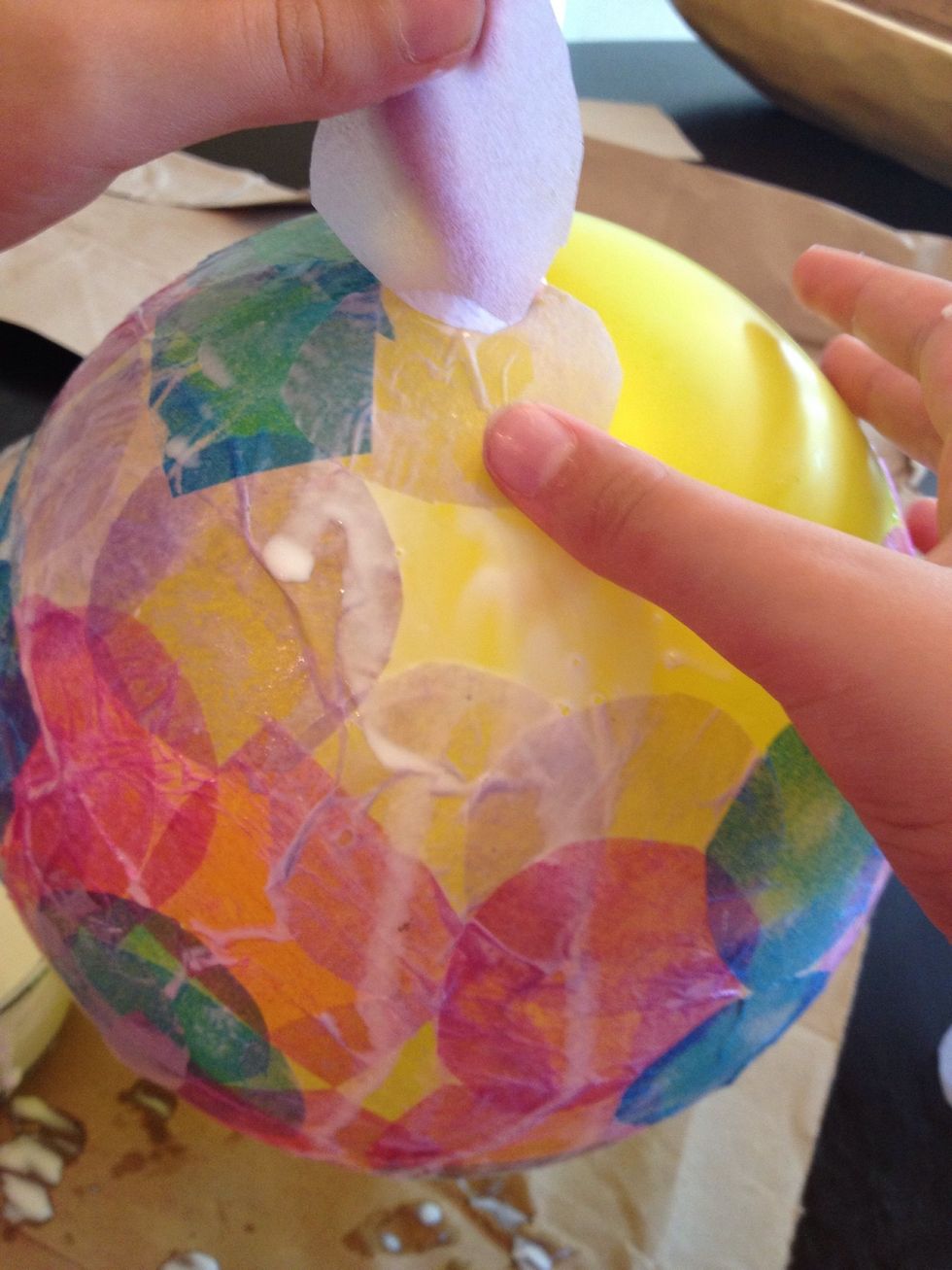 Continue until the top half (or as much as you want) of the balloon is covered. It is helpful to create a defined edge with the tissue where you want the rim of the bowl to be.