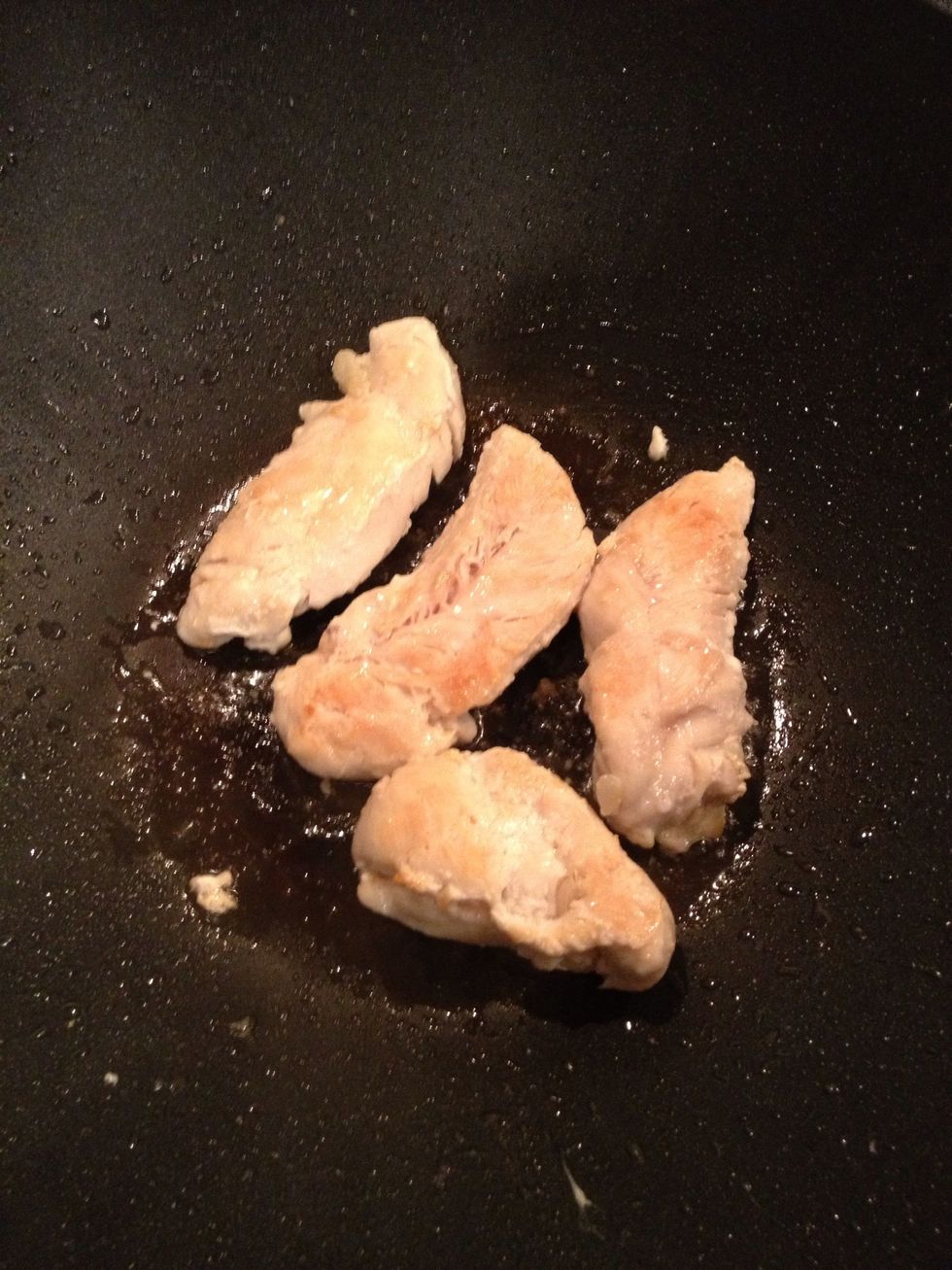 Cook chicken breasts in heated oil. If you cut them in half, they will cook faster.