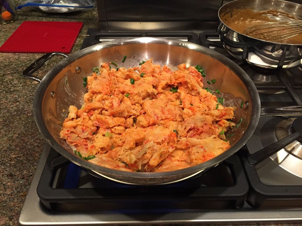 Cook crawfish and green onions in butter