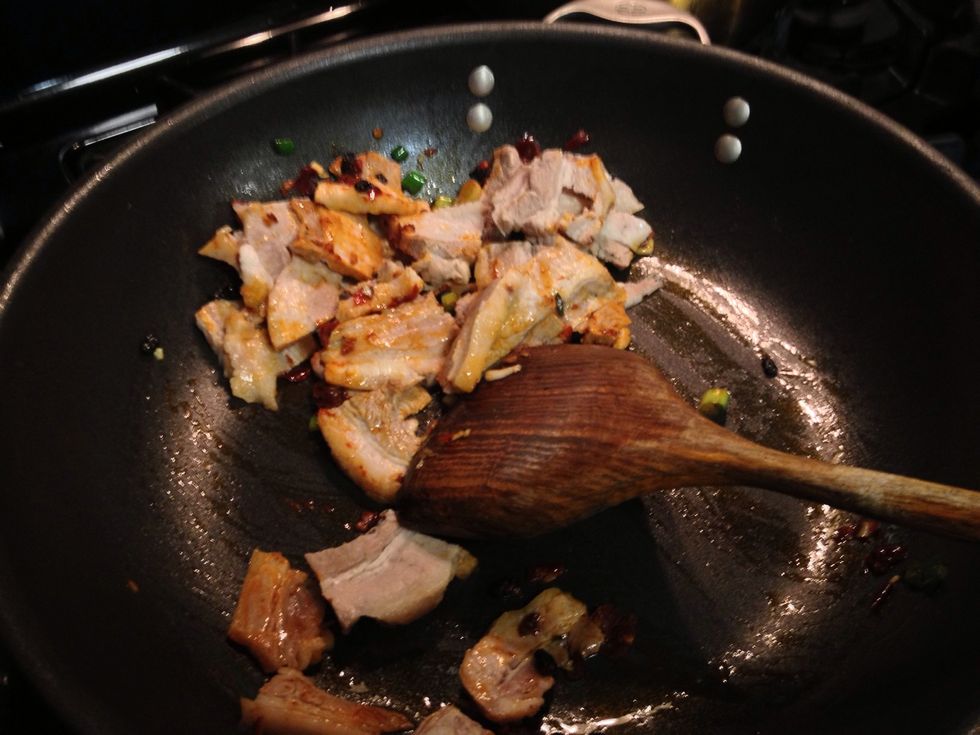 Cook on high heat. Add spicy bean paste an black beans in the pan, saut\u00e9 for 30 seconds. Add sliced pork belly, stir fry for about 3 mins.