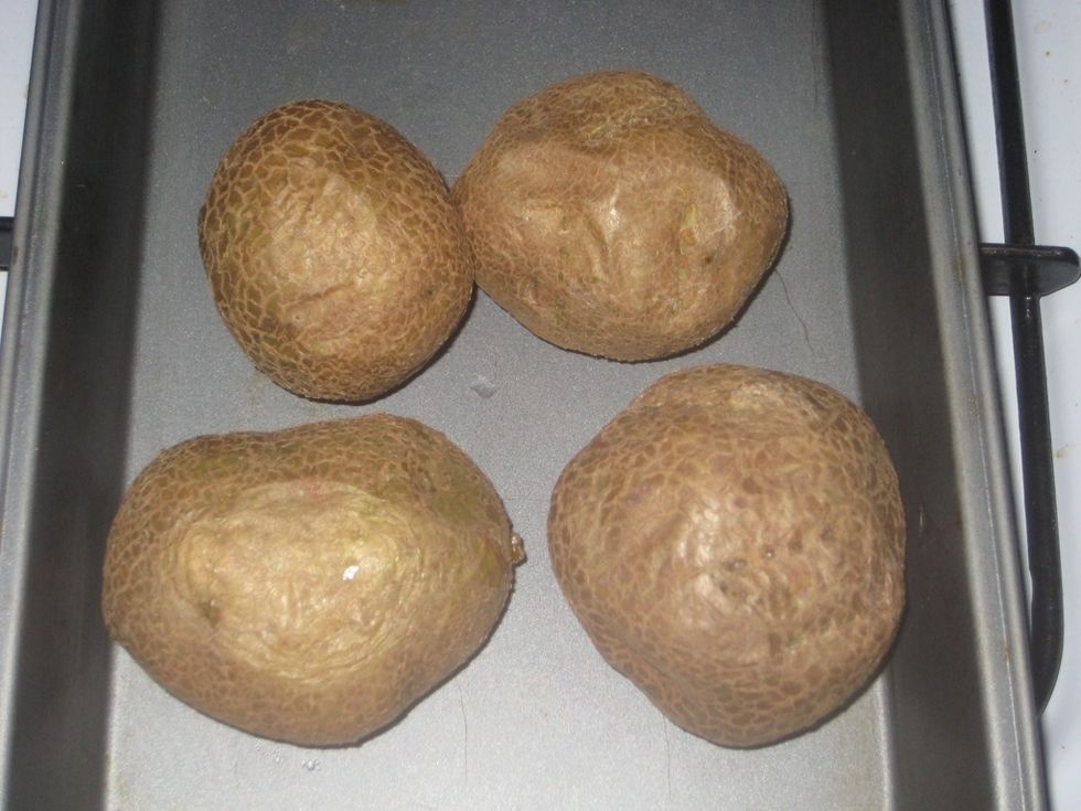 Cook the potatoes in a preheated oven @ 200C/400F(gas 6). Using a fork prick the potatoes before cooking. They are ready after about 45 minutes or when tender. Reduce oven heat to 180C/350(gas 4)