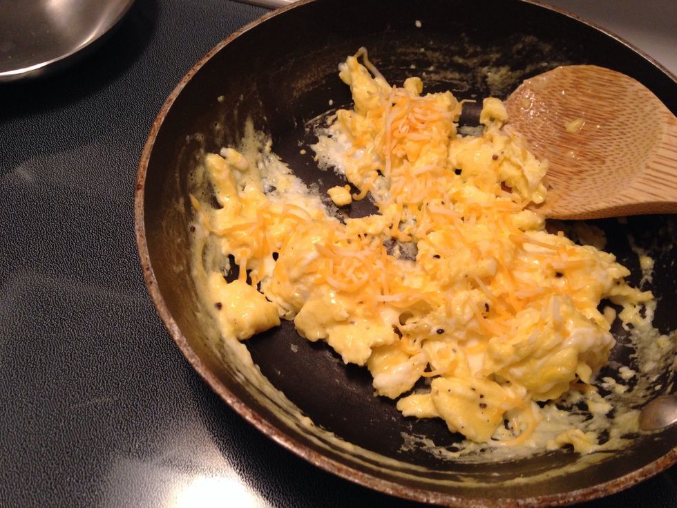 Cooks eggs half way then add as much cheese as you want!