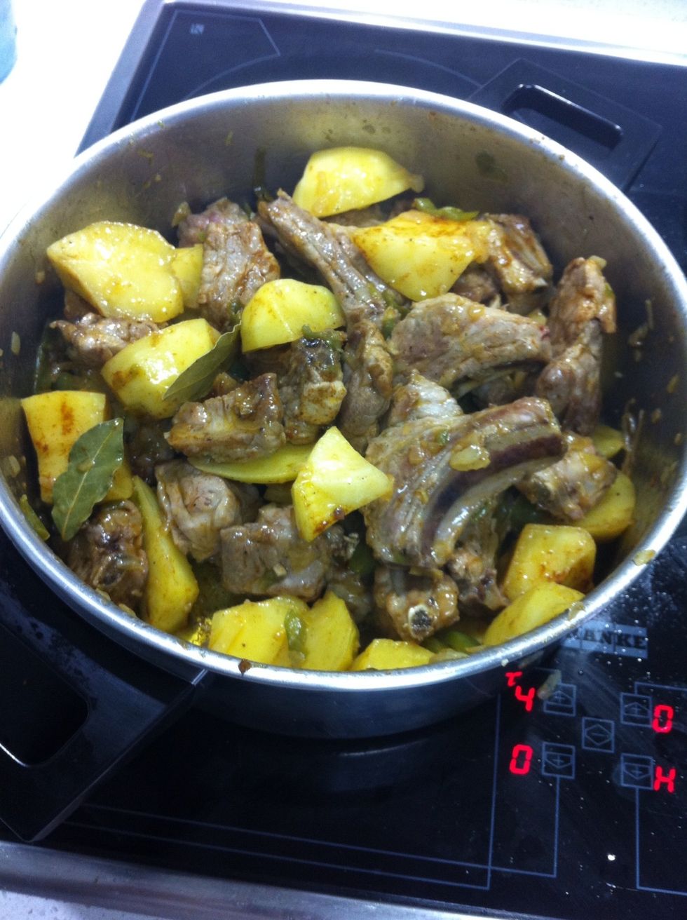 Costillas con las patatas y el sofrito una vez a\u00f1adido el piment\u00f3n y el laurel.