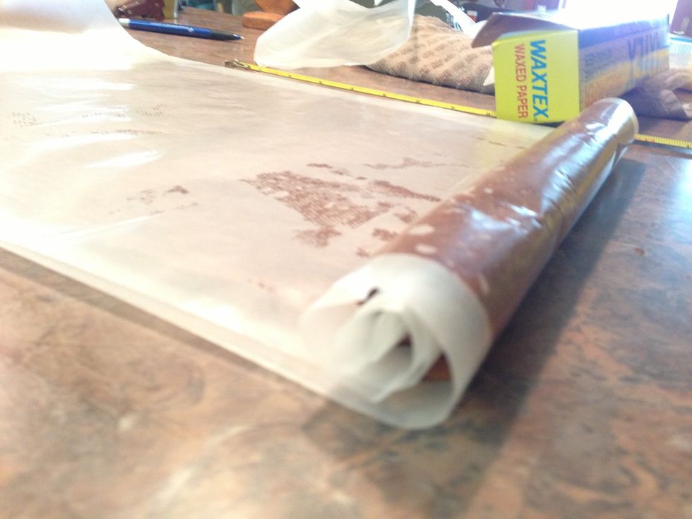 Cover chocolate rectangle with another sheet of wax paper. Carefully roll up with wax paper on both top and bottom. This is what will make it possible to later UNROLL on top of the white layer.